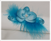 rond de serviette en fil métal bleu turquoise avec plumes et orchidée